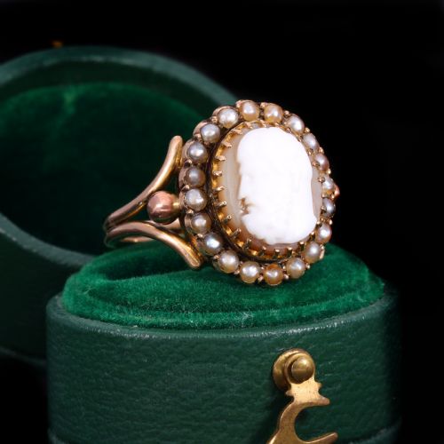 fig 1. A Victorian yellow gold ring set with an oval carved shell cameo profile encircled by a halo of seed pearls.