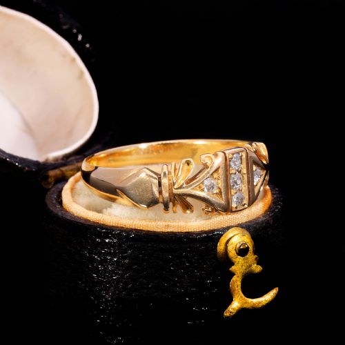 fig 2. An Edwardian yellow gold ring featuring five inset diamonds within an ornate engraved pattern band.