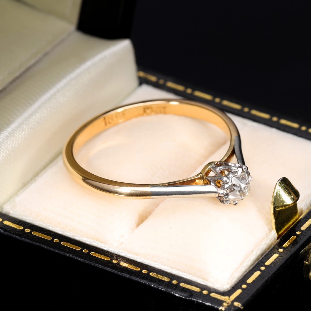 A vintage solitaire ring featuring an old mine cut diamond in a platinum multi-claw setting on a yellow gold band. View III