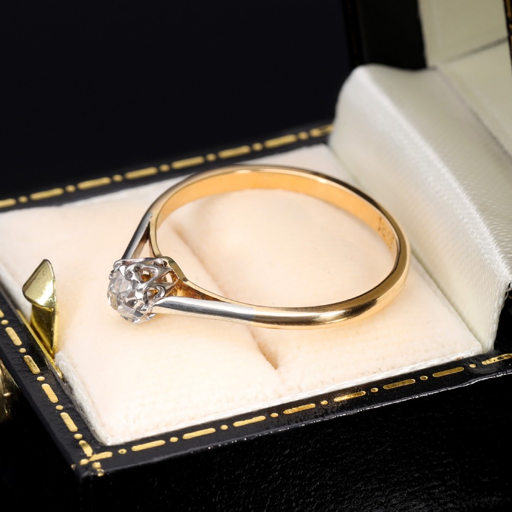 A vintage solitaire ring featuring an old mine cut diamond in a platinum multi-claw setting on a yellow gold band. View IV