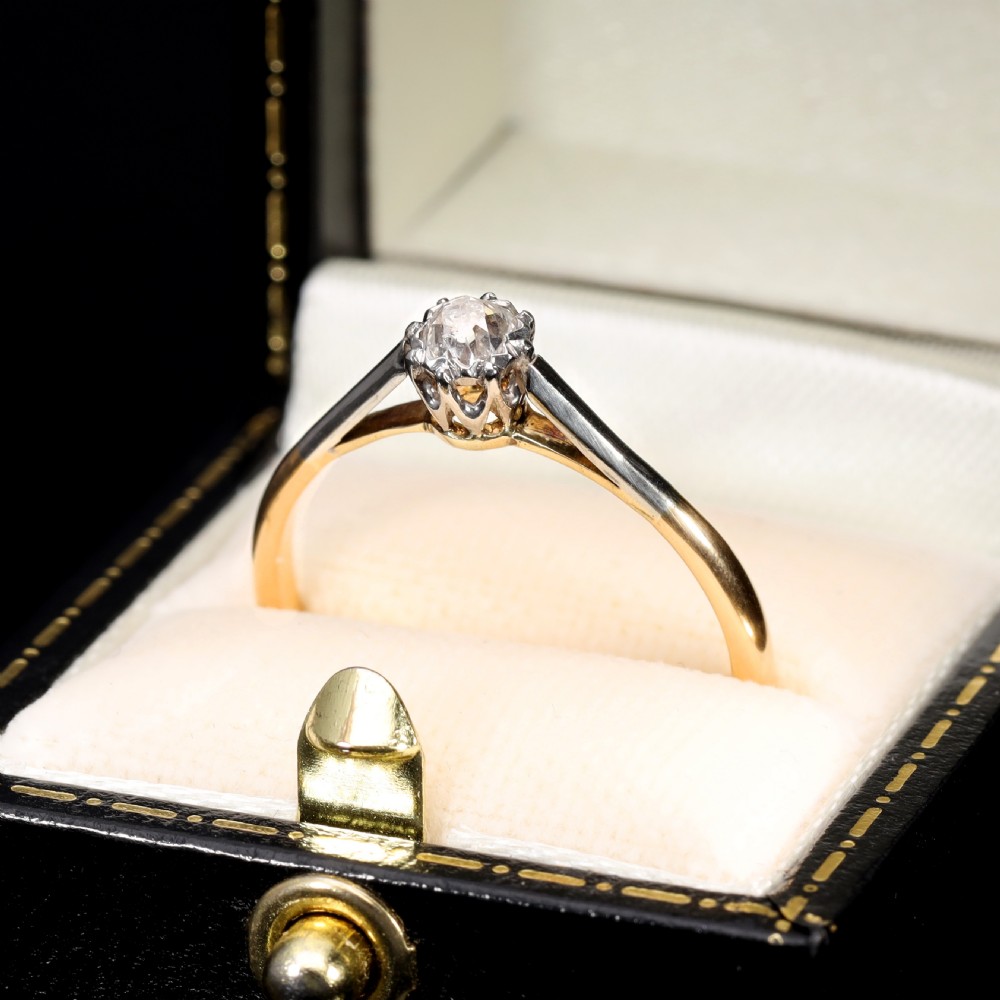 A vintage solitaire ring featuring an old mine cut diamond in a platinum multi-claw setting on a yellow gold band. View V