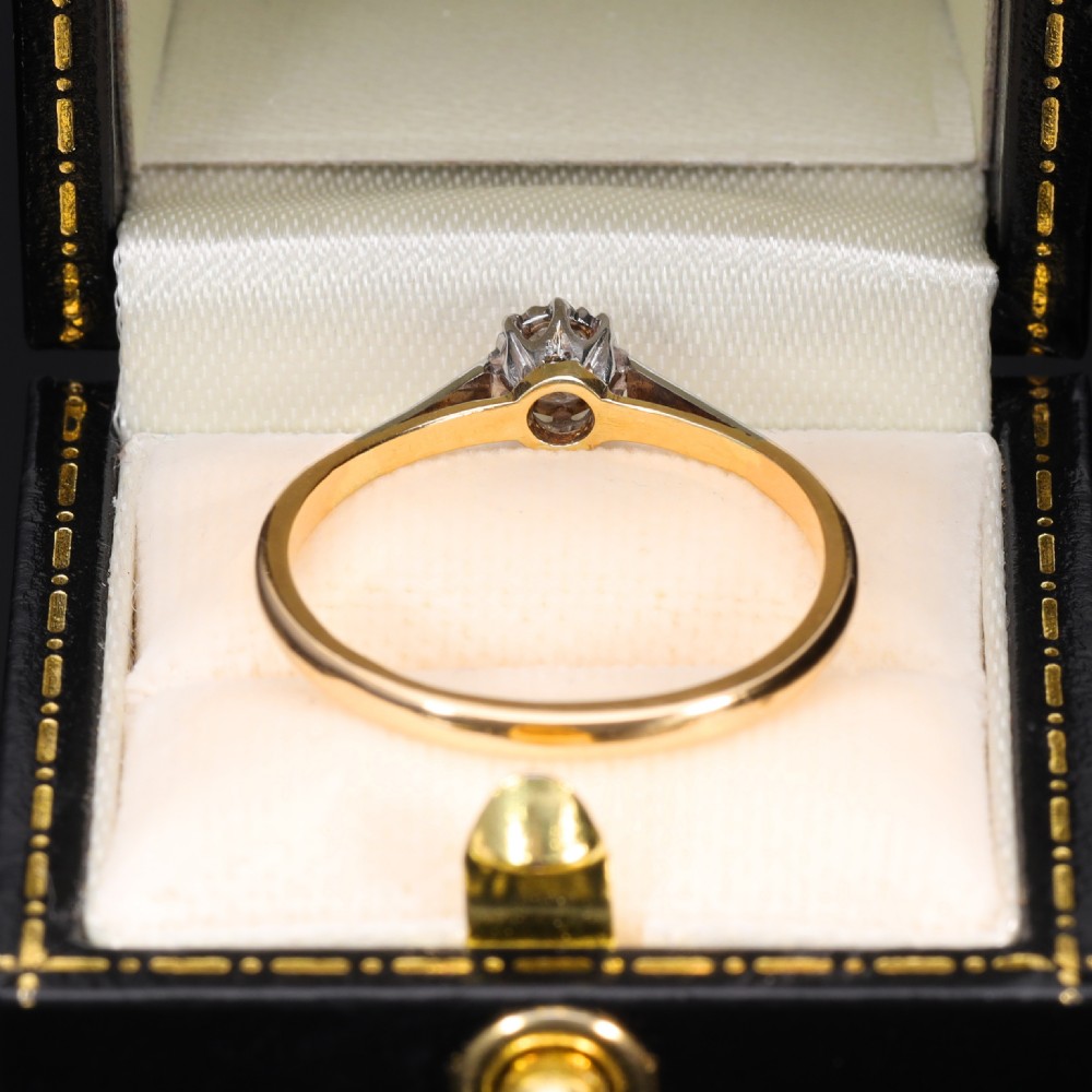 A vintage solitaire ring featuring an old mine cut diamond in a platinum multi-claw setting on a yellow gold band. View VI