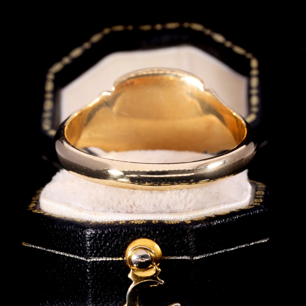 A yellow gold signet ring featuring a cushion-shaped face hand-engraved with cursive initials and delicate scrollwork details on the shoulders. View VII