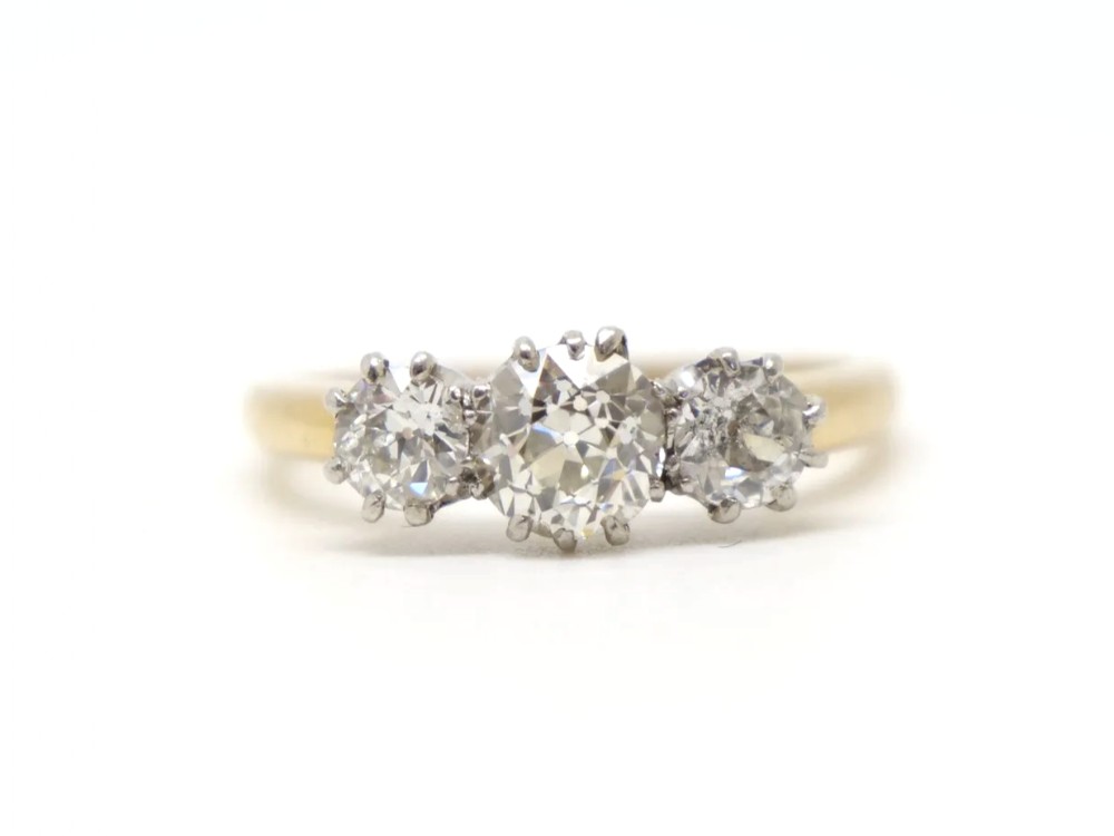 A vintage 18ct yellow gold ring featuring three round old-cut diamonds set side by side in claw settings.