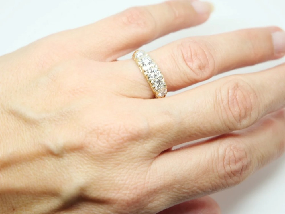 A vintage 18ct yellow gold ring featuring five brilliant-cut diamonds set in a horizontal row across the band. View V