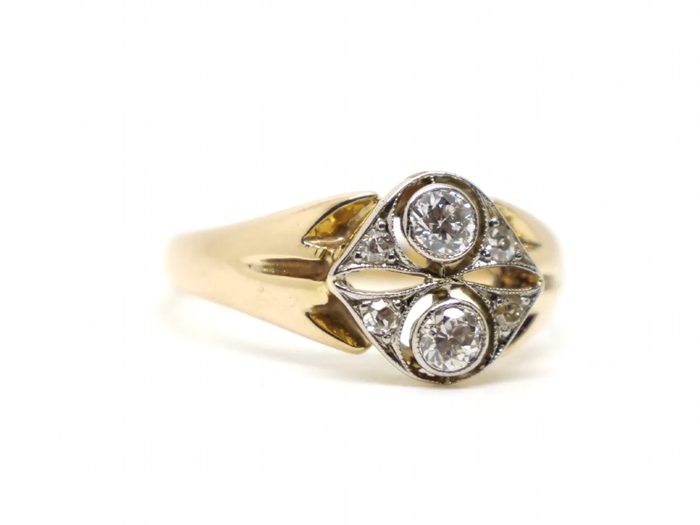 An Art Deco two-stone diamond ring crafted in 18ct yellow gold with a geometric white metal setting featuring two main diamonds and small accent stones. View III