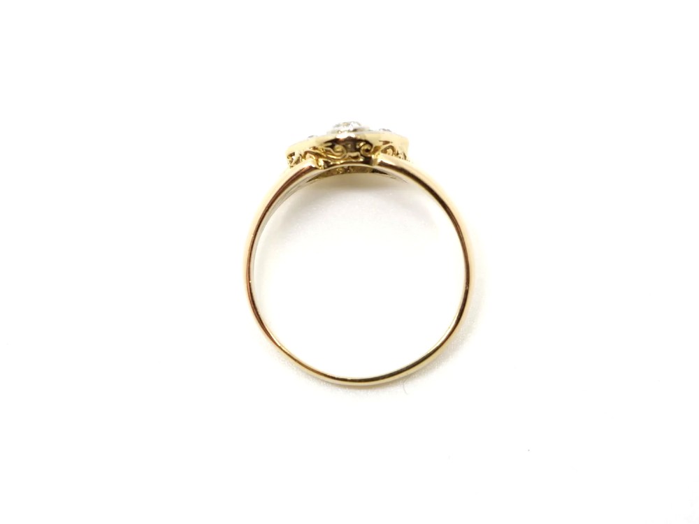 An Art Deco two-stone diamond ring crafted in 18ct yellow gold with a geometric white metal setting featuring two main diamonds and small accent stones. View IV