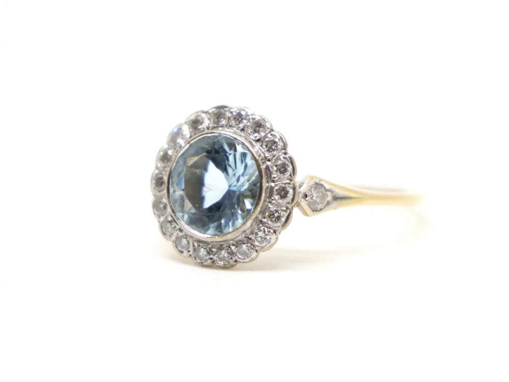 A round-cut light blue aquamarine ring surrounded by a circular diamond halo setting on a gold band. View III