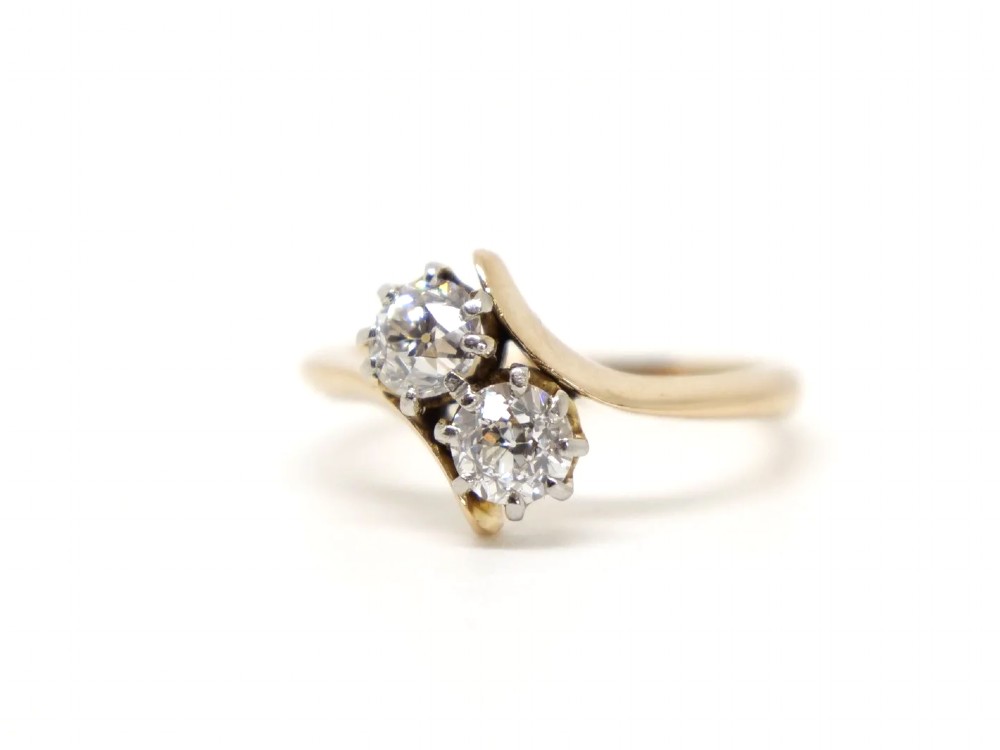 An 18ct yellow gold ring featuring a crossover band set with two round brilliant diamonds in multi-claw settings. View III