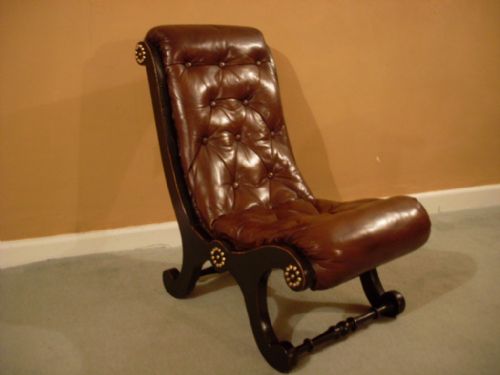 A Ebonised and Leather Upholstered Easy Chair