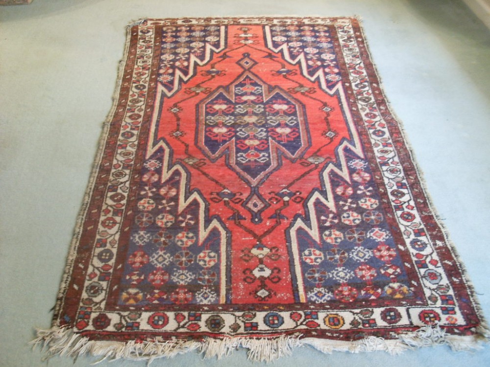 An antique rug 208 cms by 121 cms