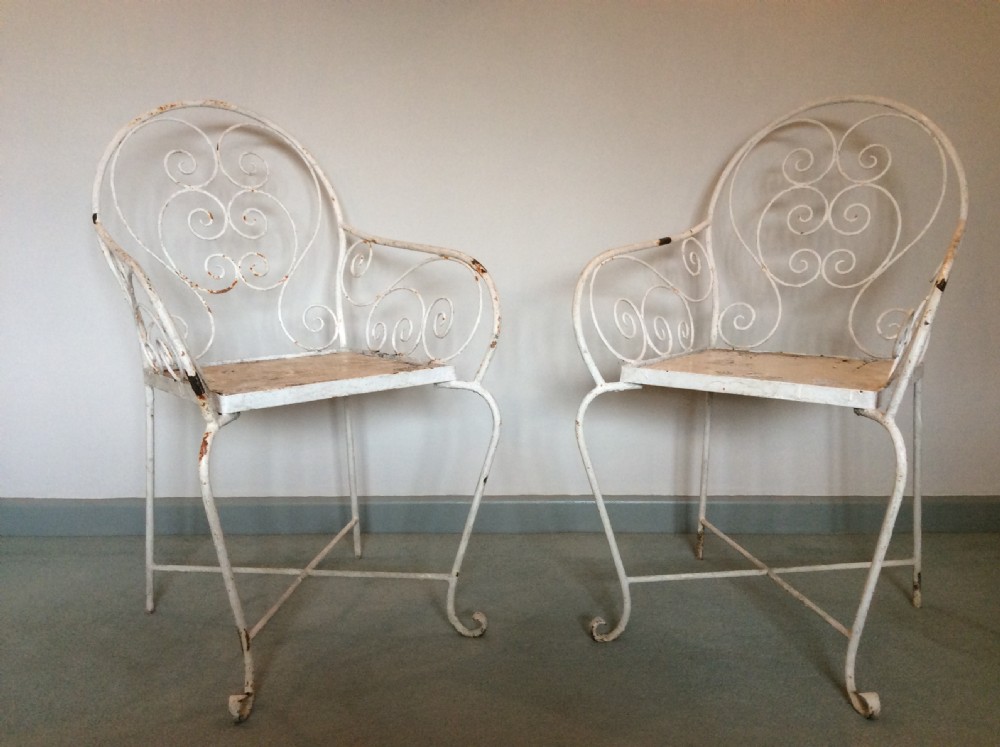 A pair of French iron garden chairs