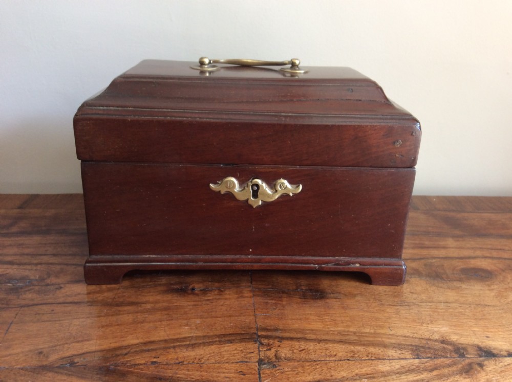 A dark mahogany Georgian tea caddy featuring a stepped lid with a top brass handle and a central brass keyhole escutcheon.