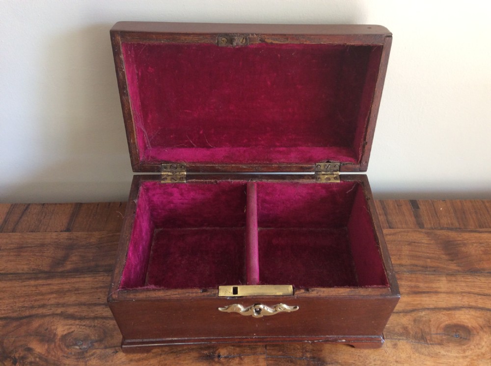 A dark mahogany Georgian tea caddy featuring a stepped lid with a top brass handle and a central brass keyhole escutcheon. View II
