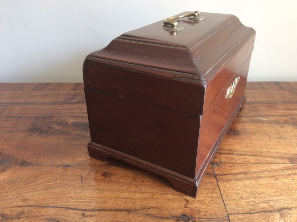 A dark mahogany Georgian tea caddy featuring a stepped lid with a top brass handle and a central brass keyhole escutcheon. View V