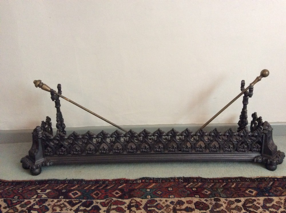 A large ornate Victorian cast iron fender