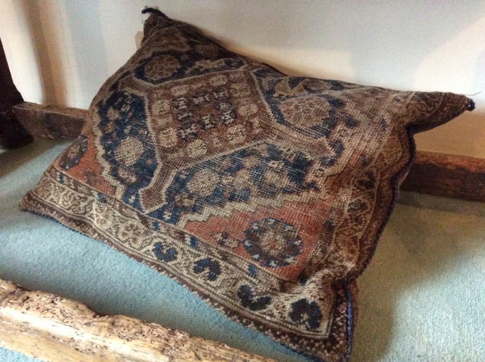 A large antique carpet cushion