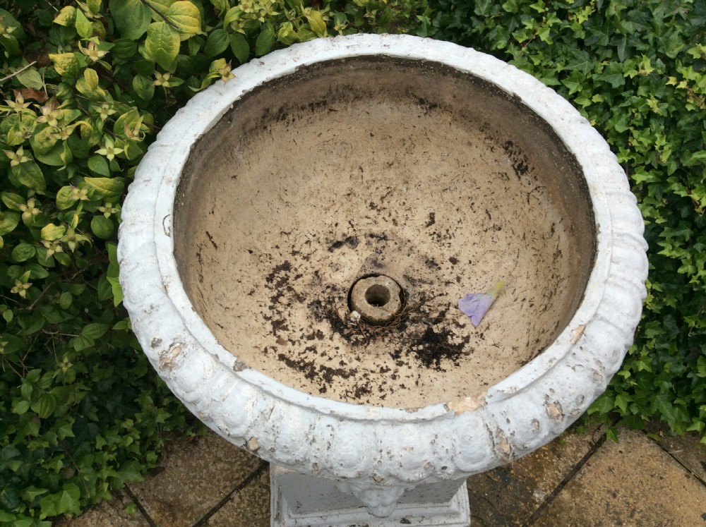 A pair of white painted 19th-century cast iron garden urns featuring gadrooned basins set upon square pedestals with lion head relief motifs. View XI