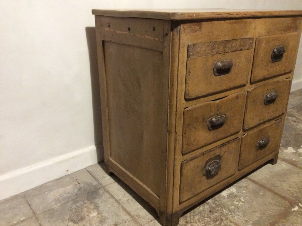 A natural pine French chest of six drawers featuring dark metal shell cup handles arranged in two vertical columns. View V