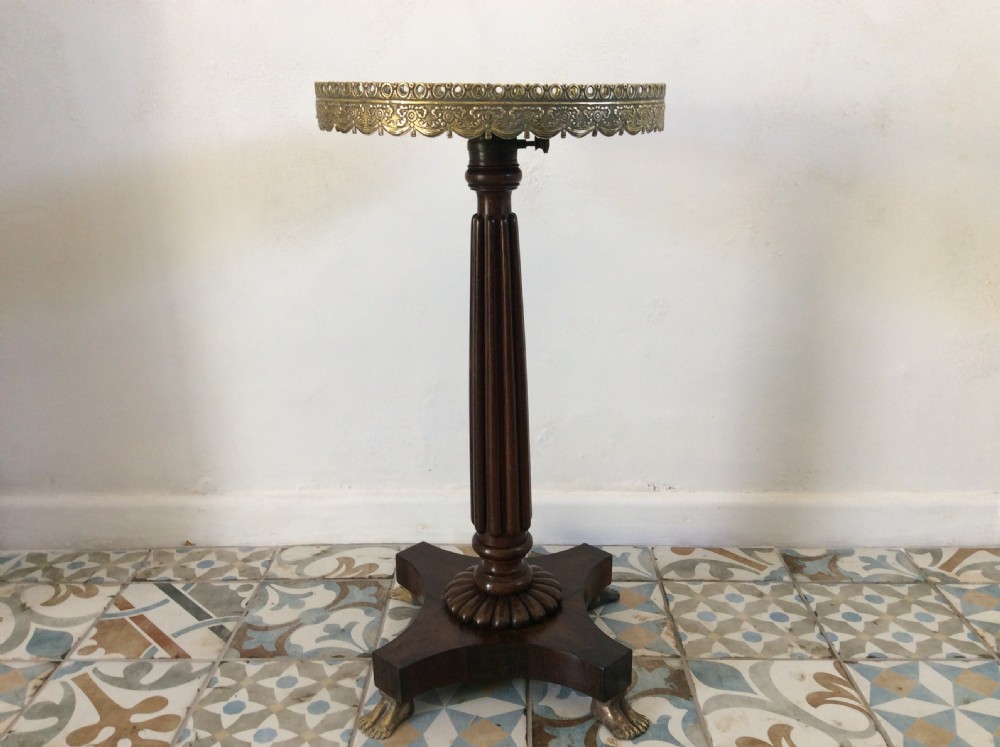 A circular French occasional table featuring a brass gallery, a reeded dark wood pedestal, and a four-point base with brass paw feet.