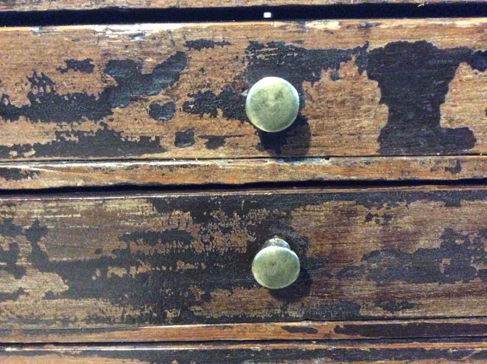 A tall and narrow dark brown wooden chest featuring nine graduated drawers with small brass knobs and a distressed finish. View V