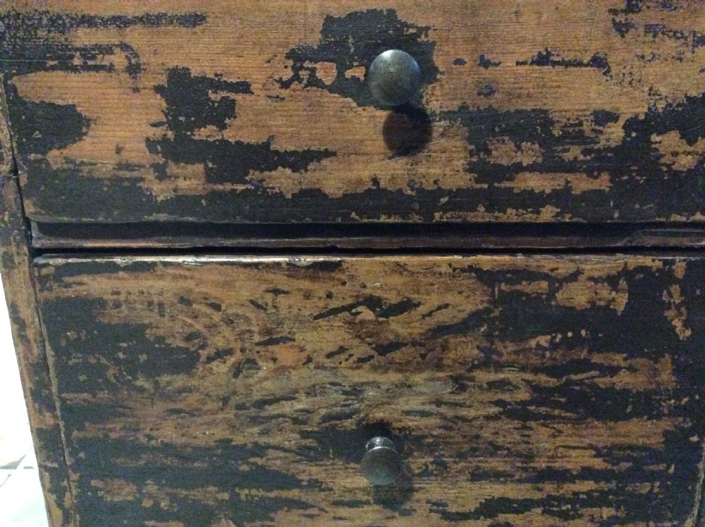 A tall and narrow dark brown wooden chest featuring nine graduated drawers with small brass knobs and a distressed finish. View VI
