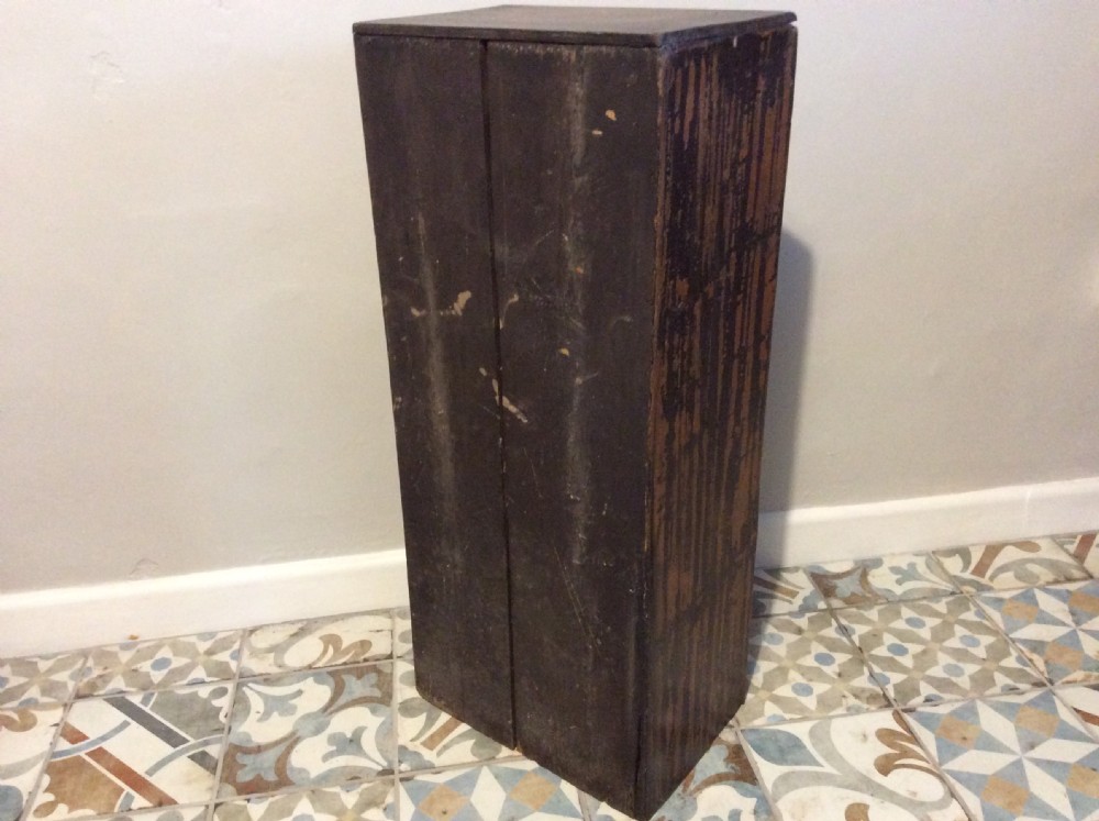 A tall and narrow dark brown wooden chest featuring nine graduated drawers with small brass knobs and a distressed finish. View VII
