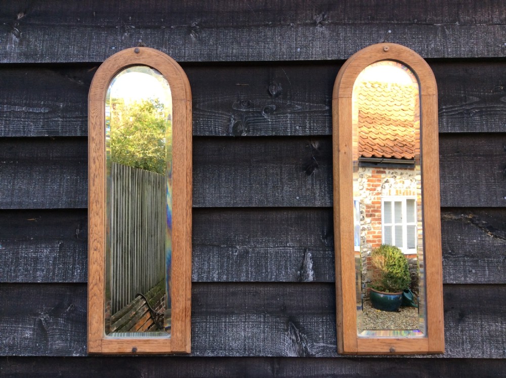 A pair of bleached oak framed pier mirrors