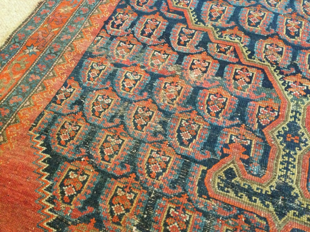 An antique hand-knotted Caucasian prayer rug displaying a central mihrab arch and repeating geometric motifs in terracotta, indigo, and navy wool. View II