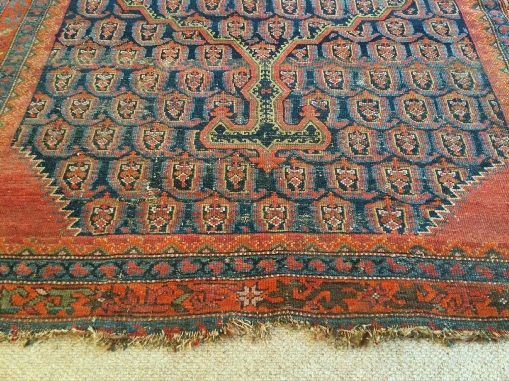 An antique hand-knotted Caucasian prayer rug displaying a central mihrab arch and repeating geometric motifs in terracotta, indigo, and navy wool. View VII