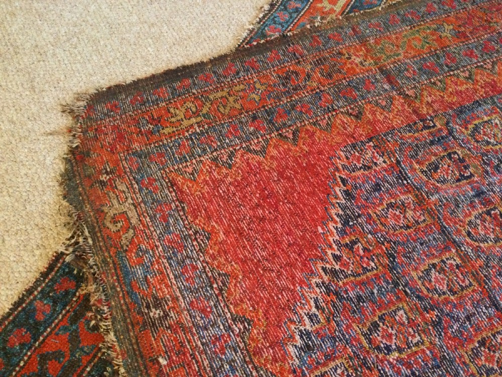 An antique hand-knotted Caucasian prayer rug displaying a central mihrab arch and repeating geometric motifs in terracotta, indigo, and navy wool. View VIII