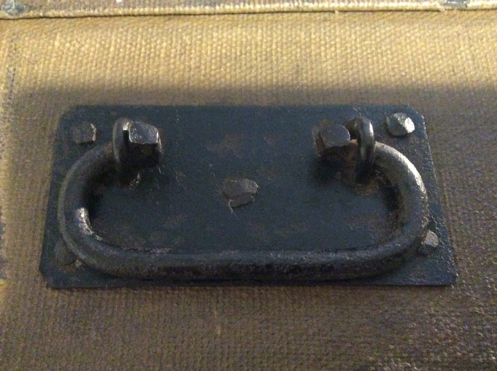 A rectangular Victorian dark brown canvas-covered trunk featuring brass corner caps, brass studs, a central lock, and stencilled black initials on the flat lid. View XVIII