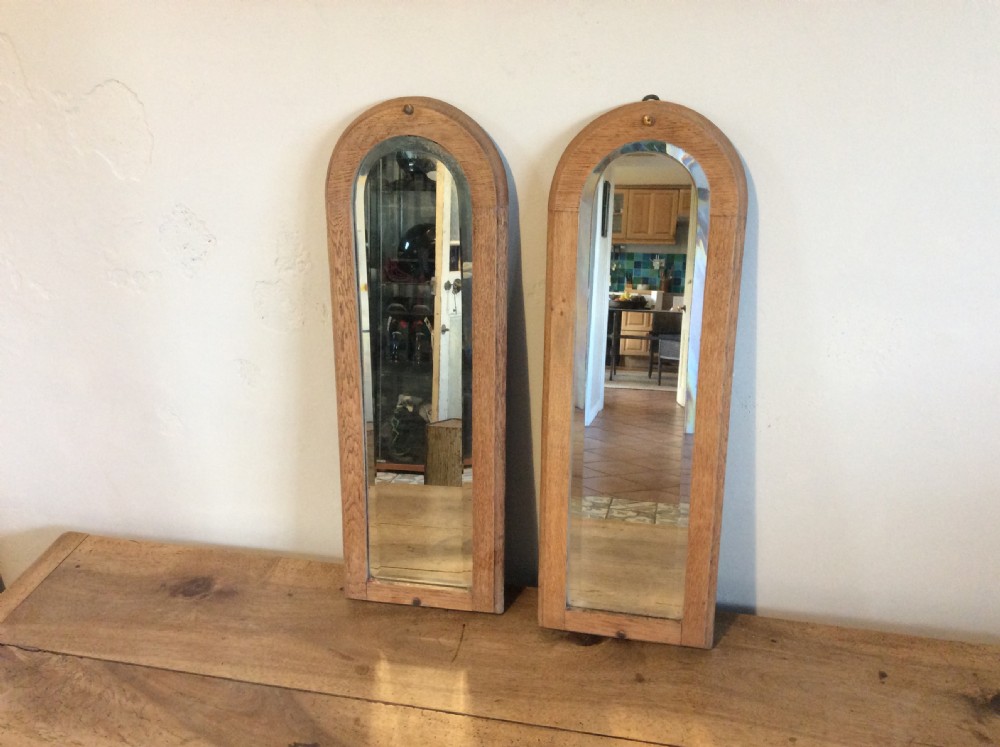 A pair of bleached oak framed pier mirrors