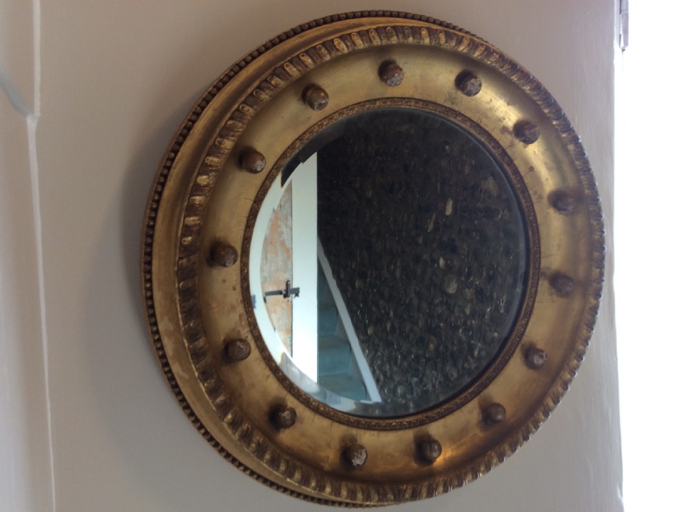 A 19th-century circular convex mirror featuring a gilded frame with decorative spherule accents. View X