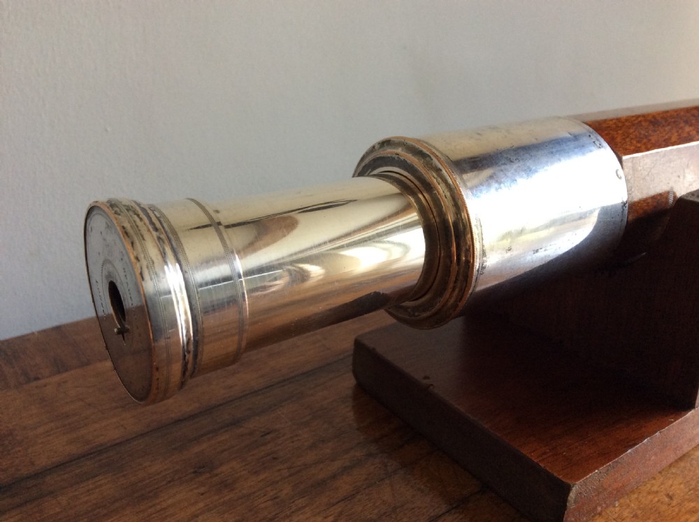 An 18th-century nine-sided mahogany and brass telescope resting on a matching wooden presentation stand. View II