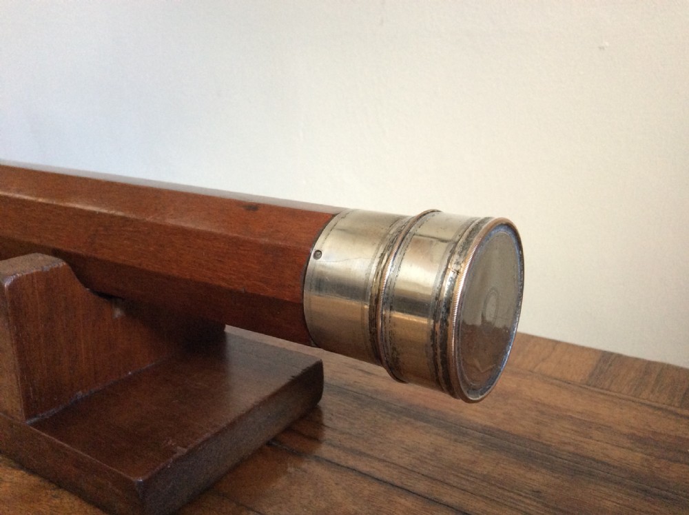 An 18th-century nine-sided mahogany and brass telescope resting on a matching wooden presentation stand. View III