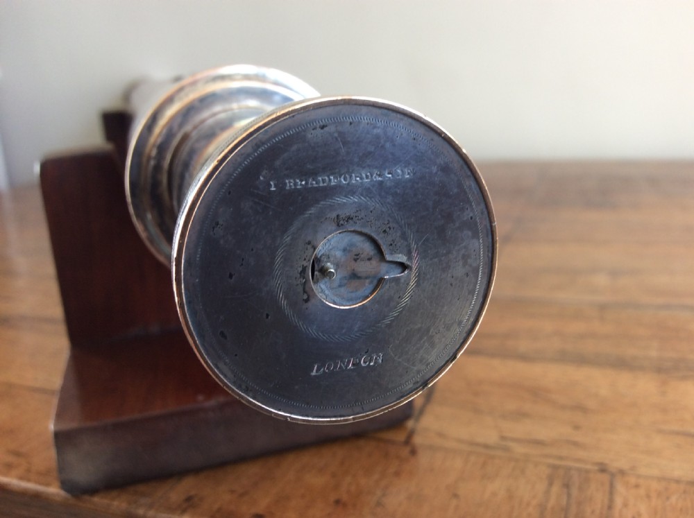 An 18th-century nine-sided mahogany and brass telescope resting on a matching wooden presentation stand. View VI