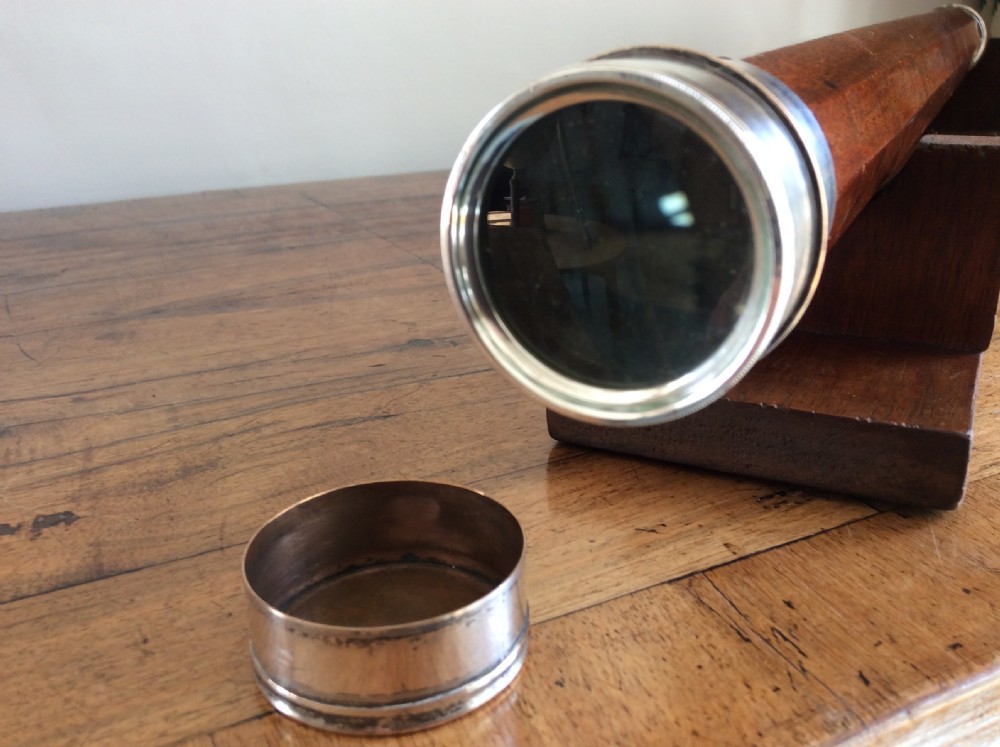 An 18th-century nine-sided mahogany and brass telescope resting on a matching wooden presentation stand. View VIII