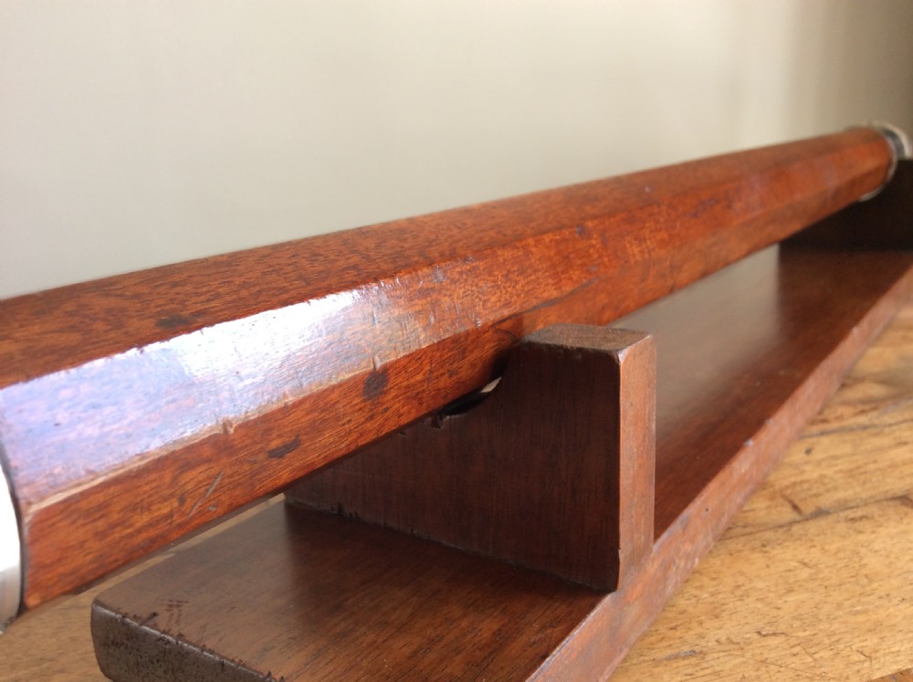 An 18th-century nine-sided mahogany and brass telescope resting on a matching wooden presentation stand. View IX