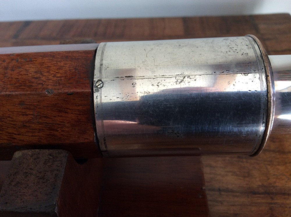 An 18th-century nine-sided mahogany and brass telescope resting on a matching wooden presentation stand. View XI