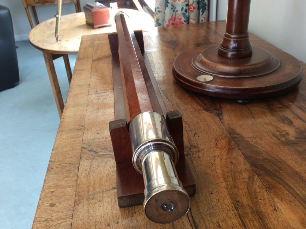 An 18th-century nine-sided mahogany and brass telescope resting on a matching wooden presentation stand. View XV