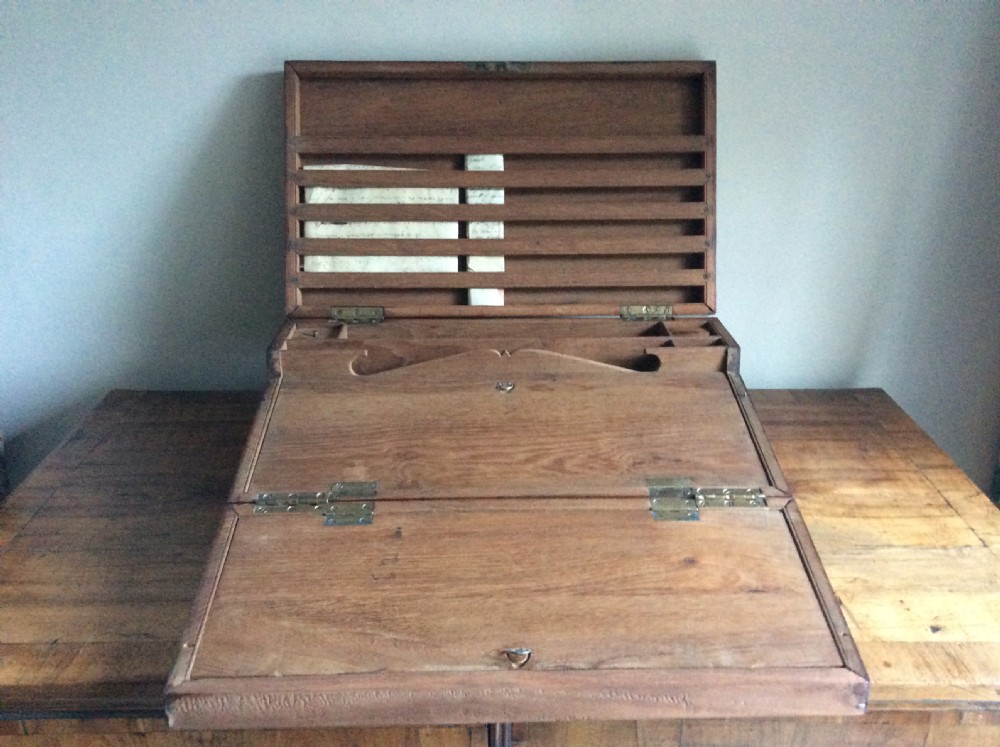 A rectangular warm brown teak campaign writing box featuring flush brass strapwork on the corners and a central decorative brass keyhole escutcheon. View III