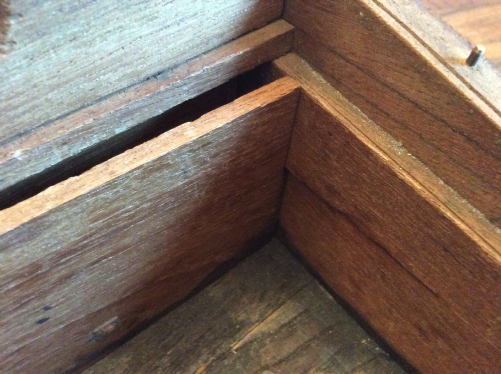 A rectangular warm brown teak campaign writing box featuring flush brass strapwork on the corners and a central decorative brass keyhole escutcheon. View X