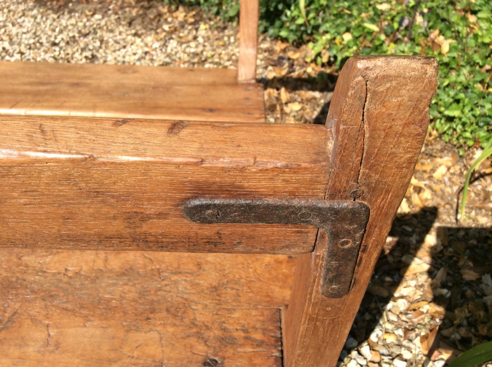 A pair of matching warm brown timber benches featuring low backrests, shaped side supports, and lower stretchers. View VI