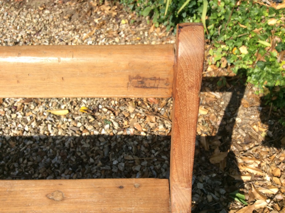 A pair of matching warm brown timber benches featuring low backrests, shaped side supports, and lower stretchers. View VII