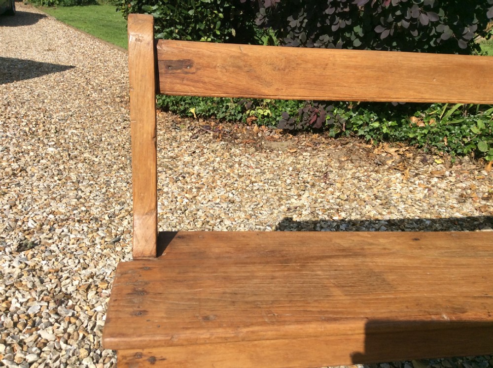 A pair of matching warm brown timber benches featuring low backrests, shaped side supports, and lower stretchers. View VIII