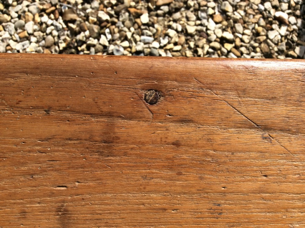 A pair of matching warm brown timber benches featuring low backrests, shaped side supports, and lower stretchers. View X