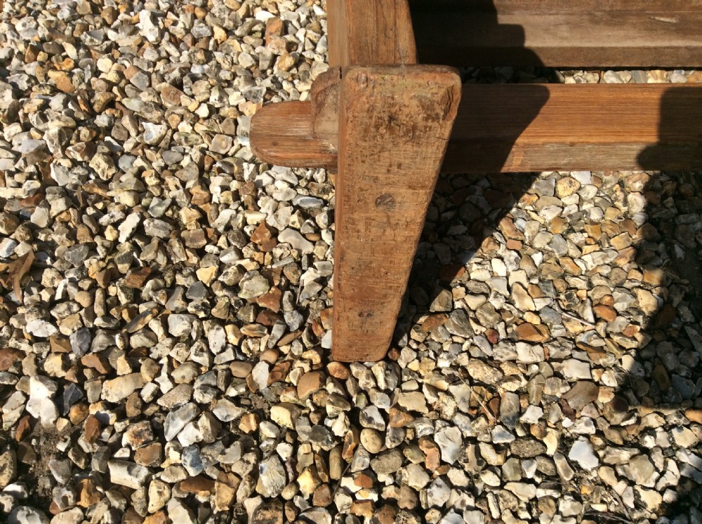 A pair of matching warm brown timber benches featuring low backrests, shaped side supports, and lower stretchers. View XI
