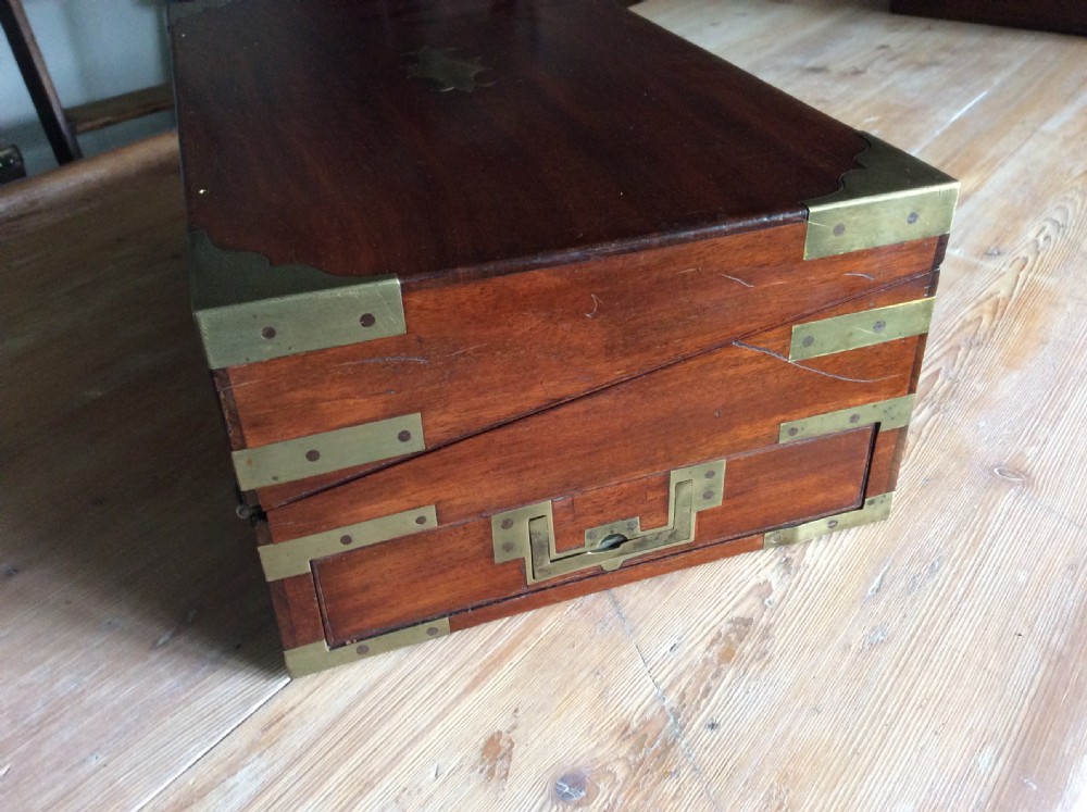 A rectangular mahogany campaign writing slope with flush brass corner brackets, brass straps, and a decorative brass keyhole escutcheon. View III