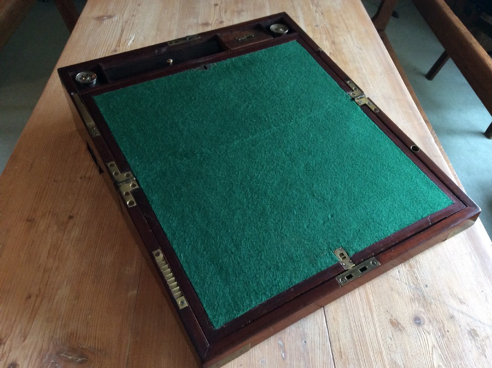 A rectangular mahogany campaign writing slope with flush brass corner brackets, brass straps, and a decorative brass keyhole escutcheon. View VIII